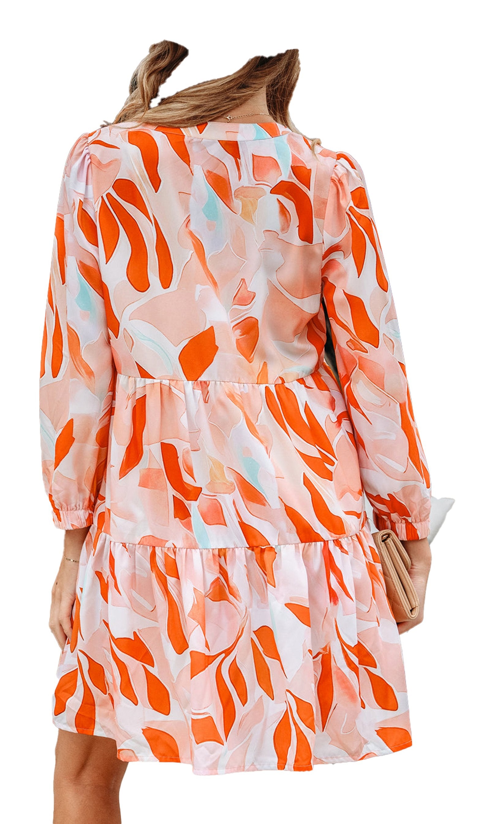 Woman wearing LuckeLadybug orange abstract print dress tiered mini with long sleeves and sun hat back view