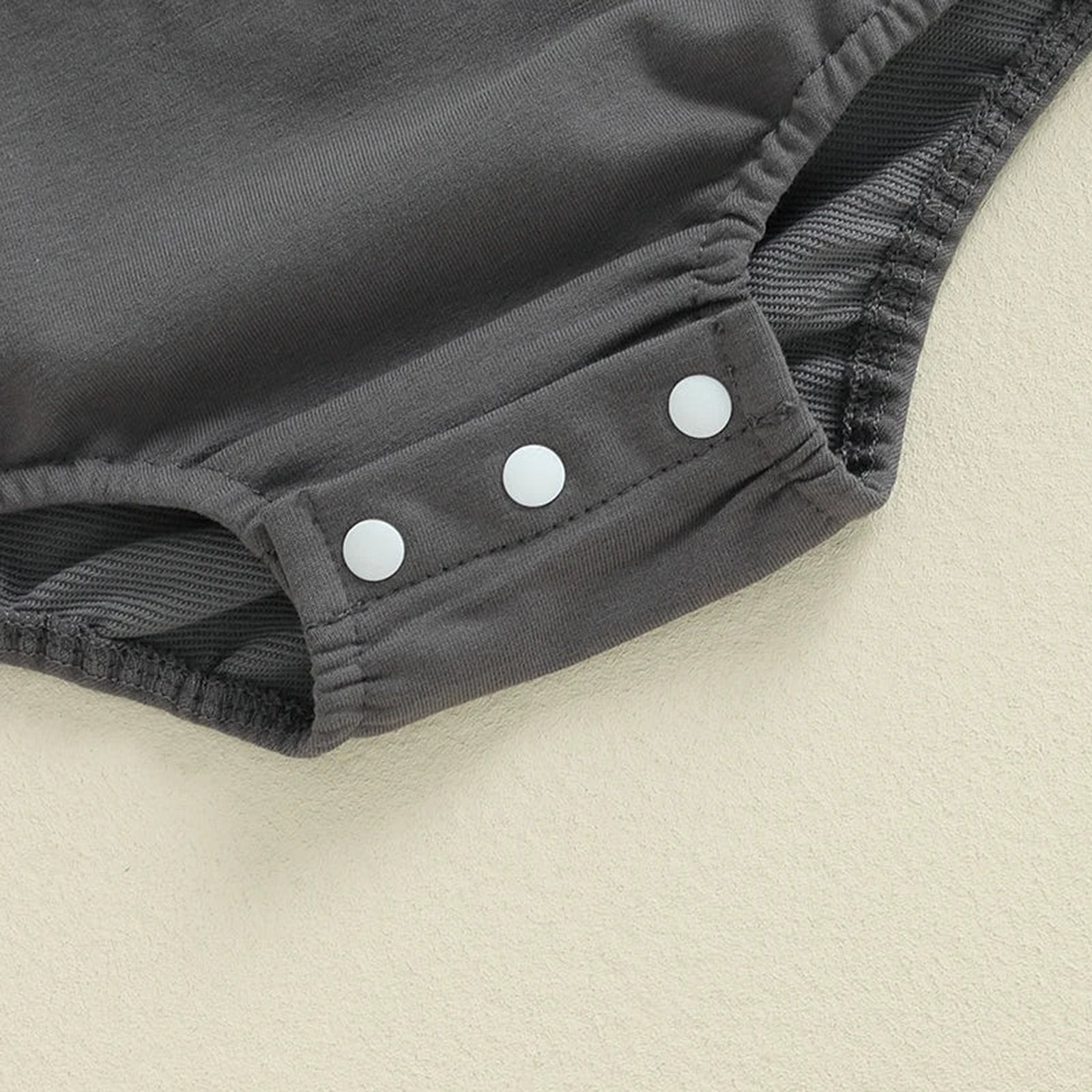 Close-up of grey baby boy Halloween romper with snap buttons for easy dressing