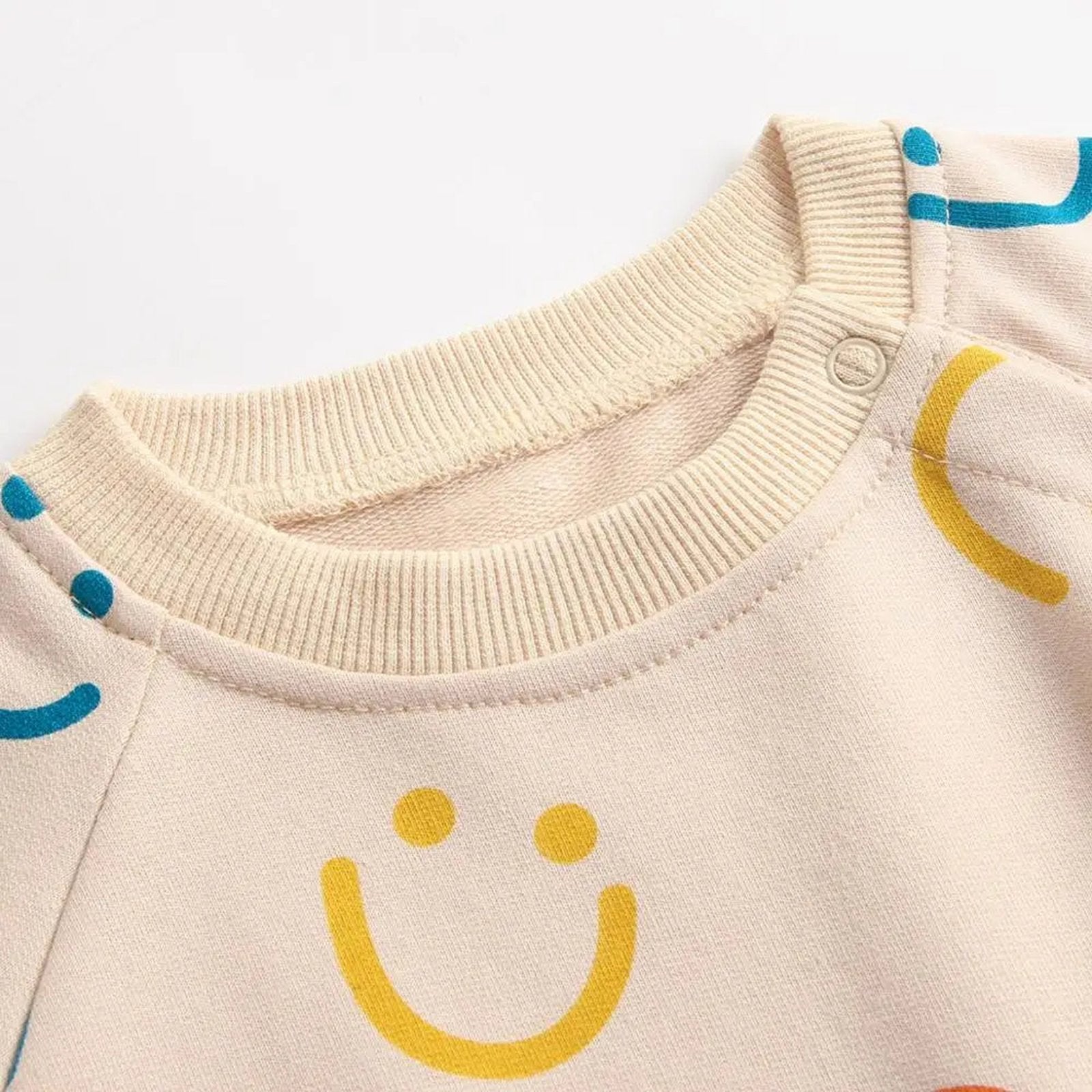 Baby girl autumn bodysuit in light beige with colorful smiley face patterns and soft ribbed neckline