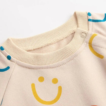 Baby girl autumn bodysuit in light beige with colorful smiley face patterns and soft ribbed neckline