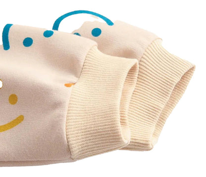 Close-up of sleeves on a baby girl autumn bodysuit featuring playful smiley designs in blue and yellow