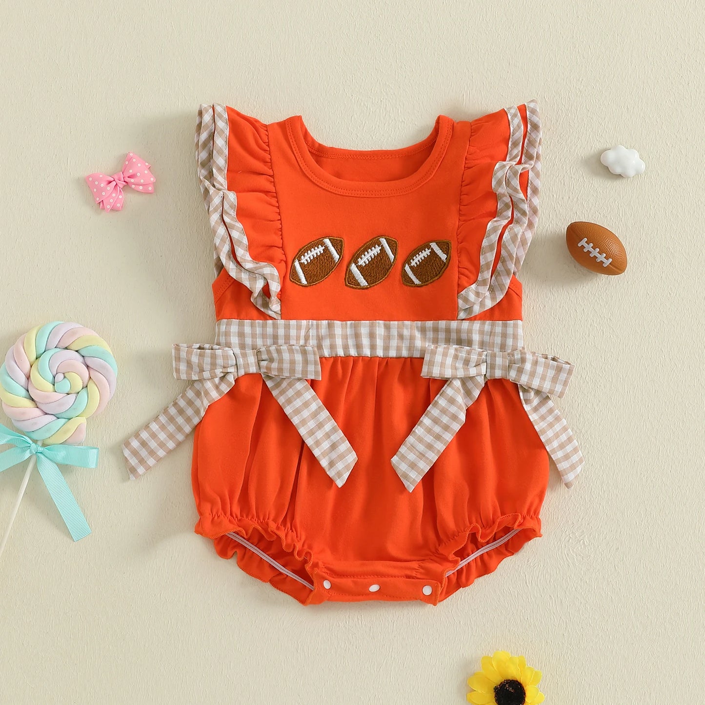 Bright orange baby girl rugby romper with football designs and plaid accents for playful outfits