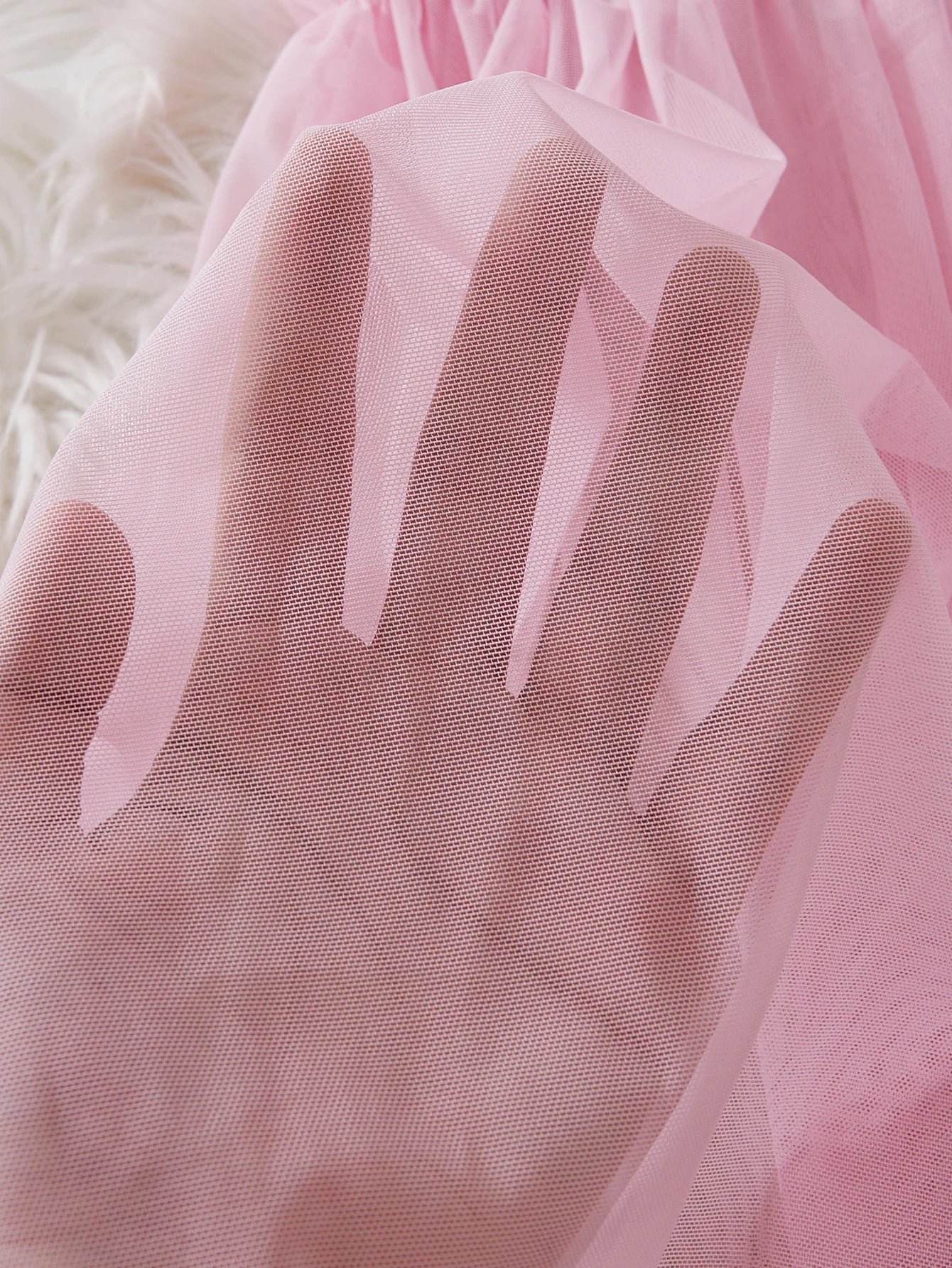 Close-up of soft pink fabric showcasing the sheer texture of a babydoll dress