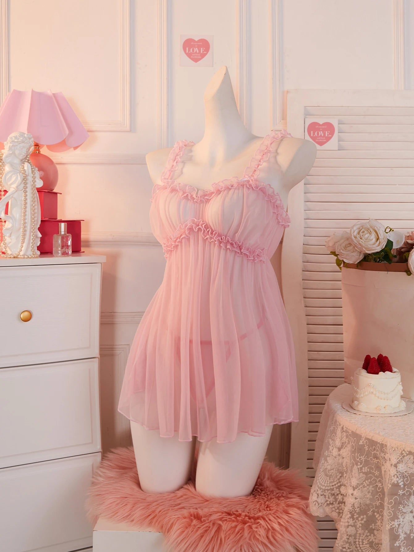 Delicate pink babydoll dress with ruffled details and sheer fabric for a romantic look