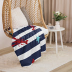 LuckeLAdybug beach theme sherpa blanket with navy and white stripes and lobster design draped on rattan hanging chair