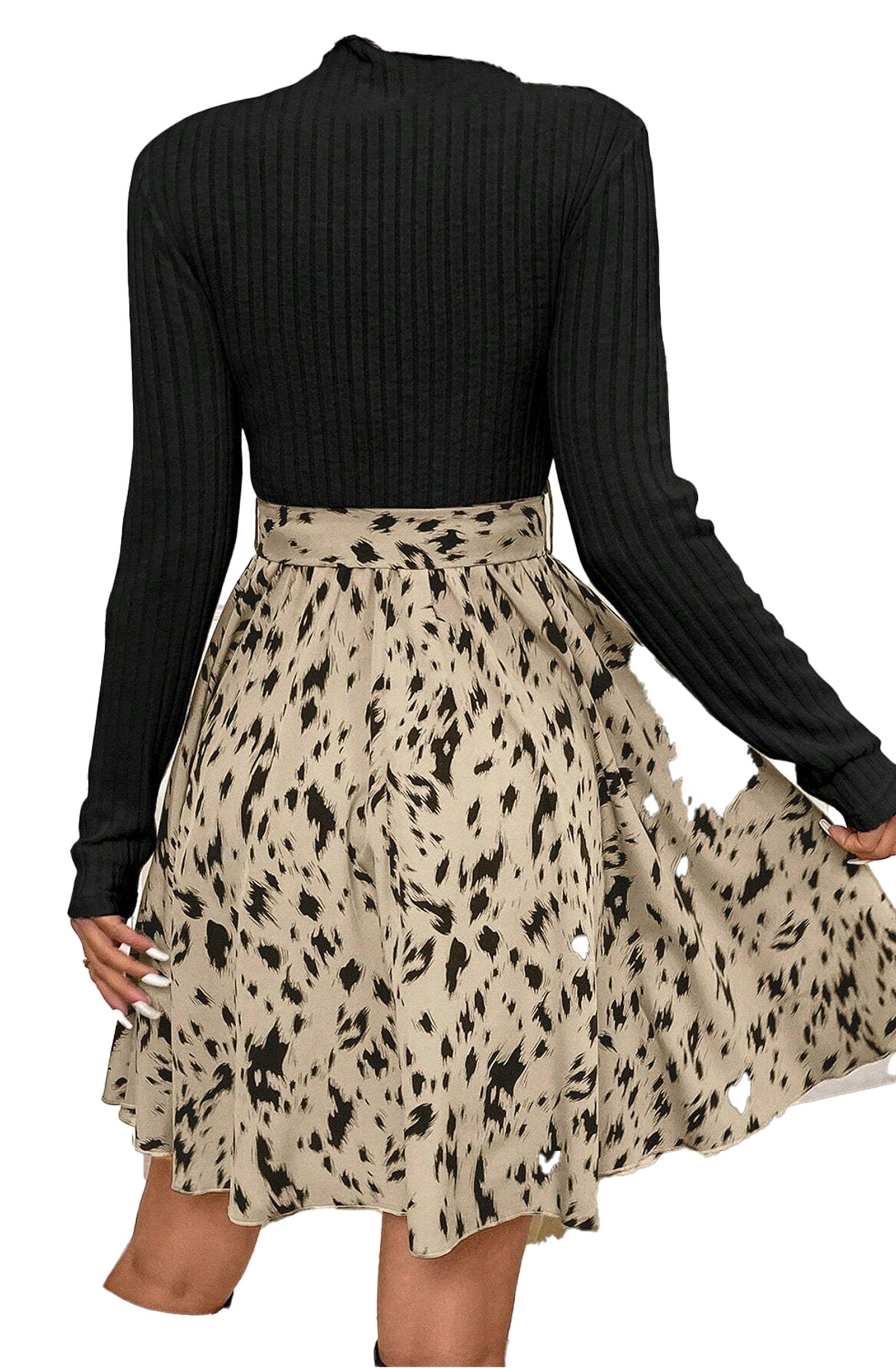 Back view of beige ribbed knit A-line dress with black ribbed long sleeves and patterned skirt with waist tie