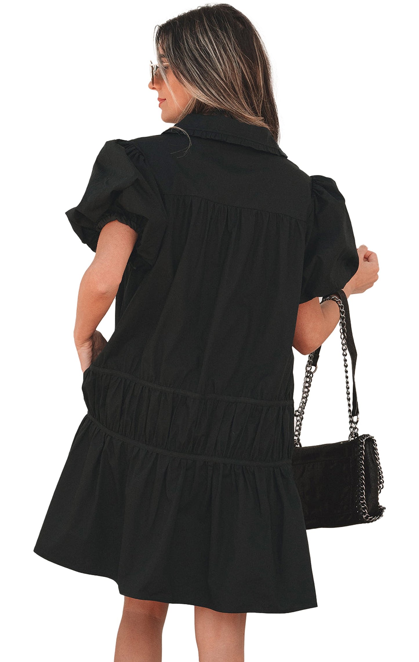Model wearing black puff sleeve shirt dress back view with tiered mini skirt collar and chain shoulder bag