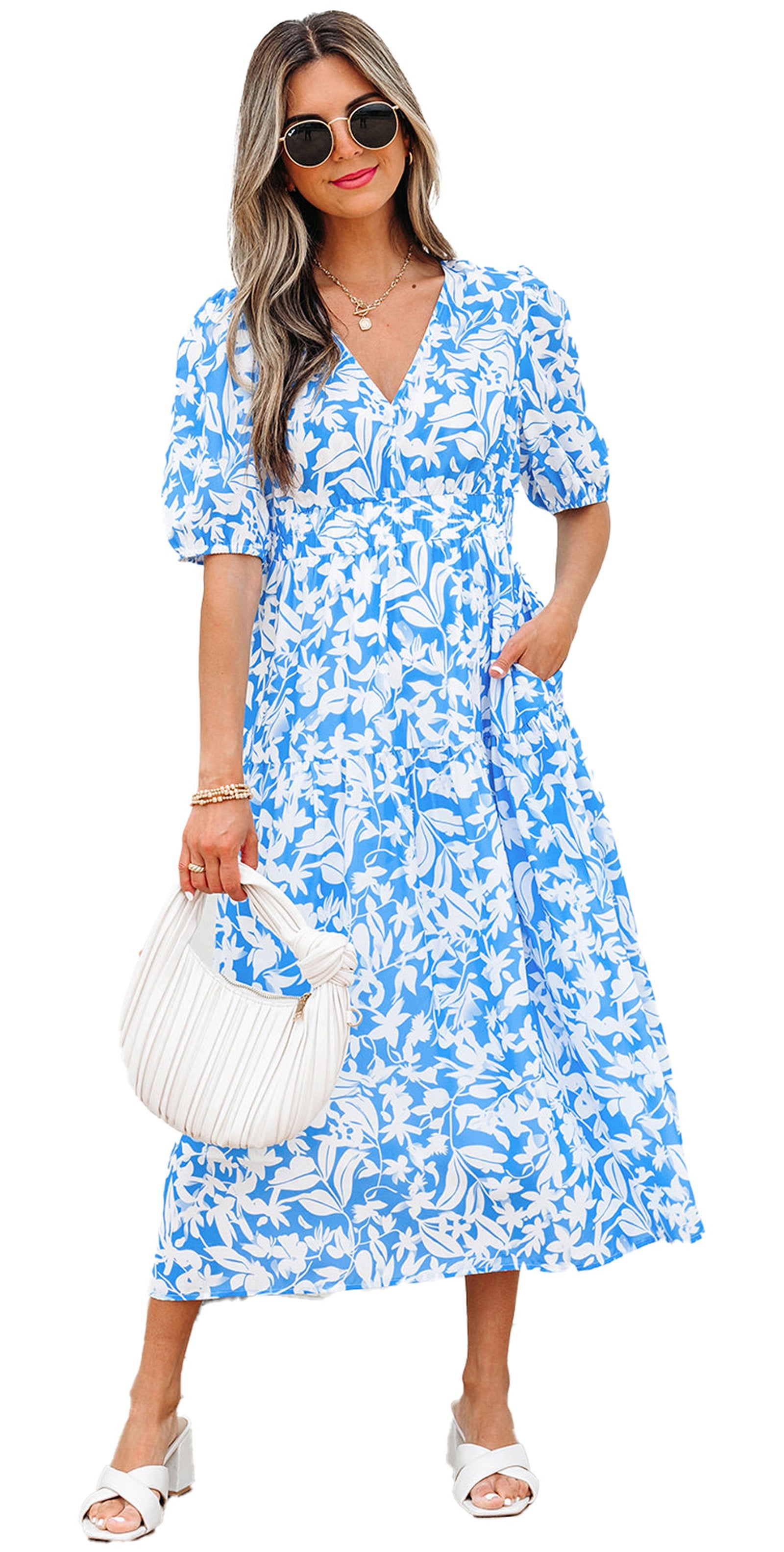 Model wearing sky blue floral maxi dress A line by LuckeLadybug with sunglasses white handbag and sandals