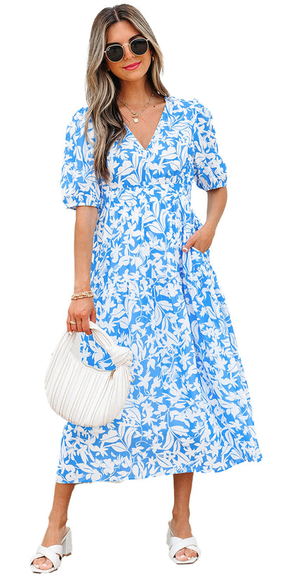 Model wearing sky blue floral maxi dress A line by LuckeLadybug with sunglasses white handbag and sandals