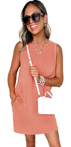 Model wearing Phalaenopsis tank mini dress with pockets in coral holding white handbag and sunglasses