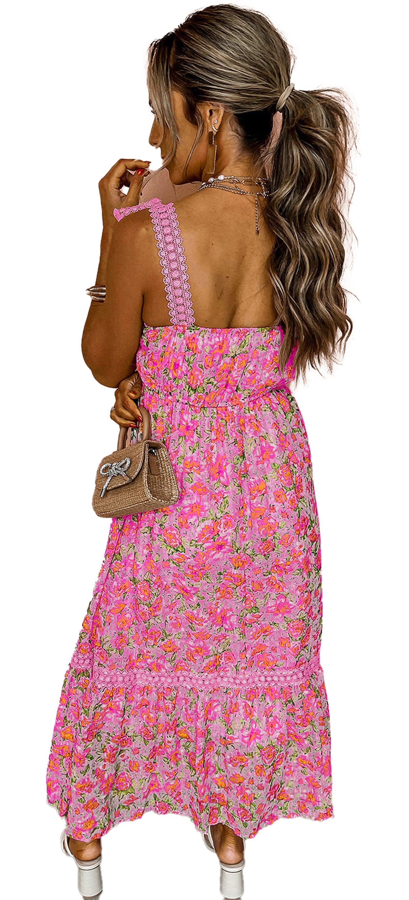LuckeLadybug pink floral maxi dress with smocked back ruffled hem textured straps model holding straw bag against peach wall