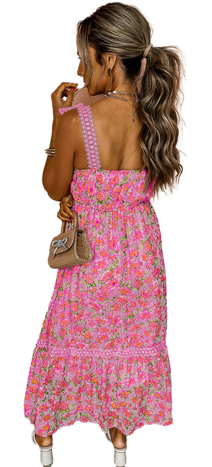 LuckeLadybug pink floral maxi dress with smocked back ruffled hem textured straps model holding straw bag against peach wall