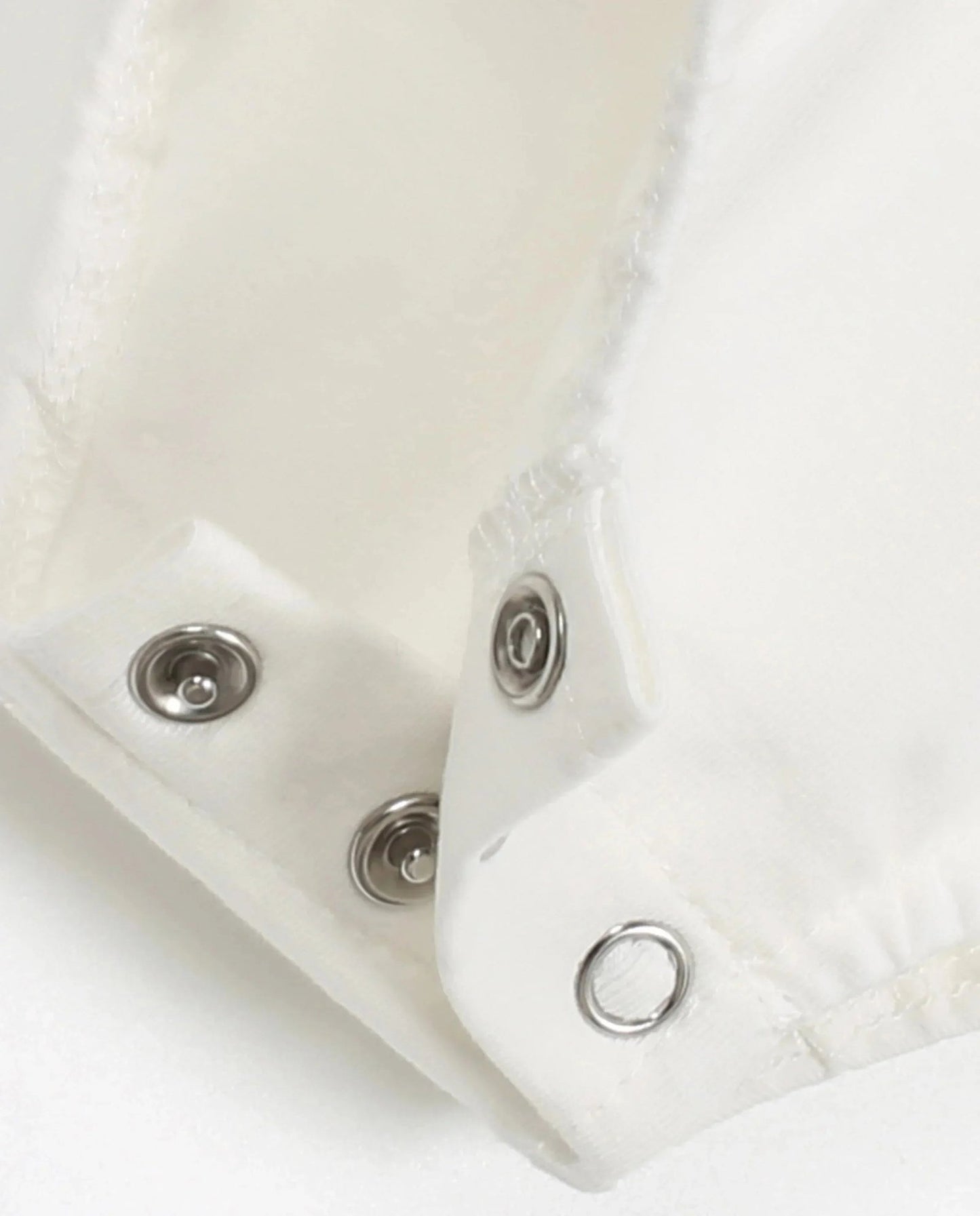 Close-up of snaps on plaid romper baby clothes for easy dressing and comfort