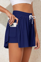 Navy boardshorts by LuckeLadybug LLC featuring a pocket and tie waist, perfect as a bikini bottom