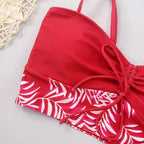 Red bikini with high waist featuring a stylish tropical leaf print design