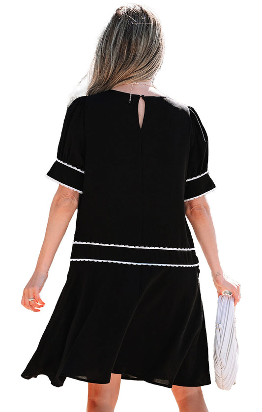 Back view of a LuckeLadybug black scallop trim dress with short sleeves and keyhole detail