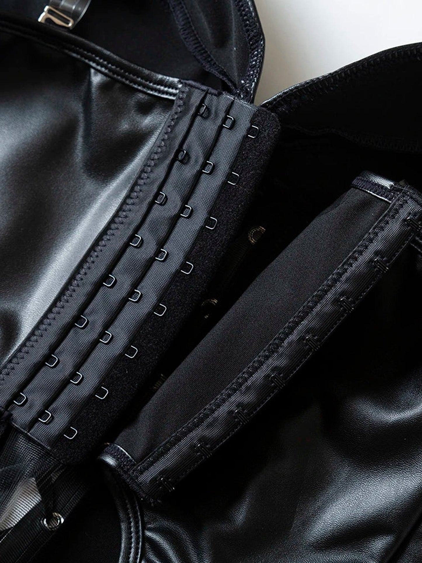 Close-up of LuckeLadybug LLC black strapless corset top showcasing hooks and sleek material