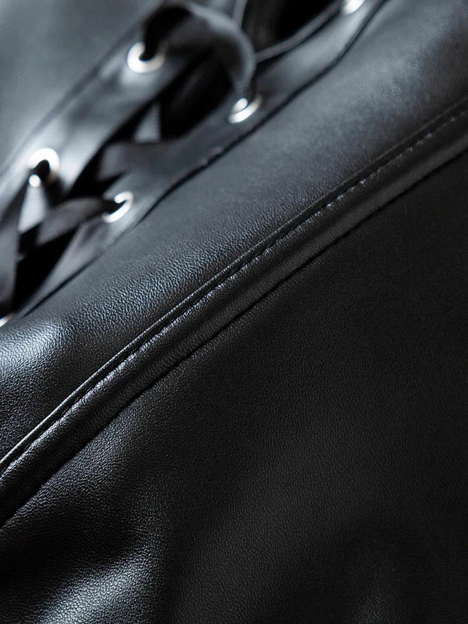 Detailed view of a black strapless corset top with lace-up design and sleek finish