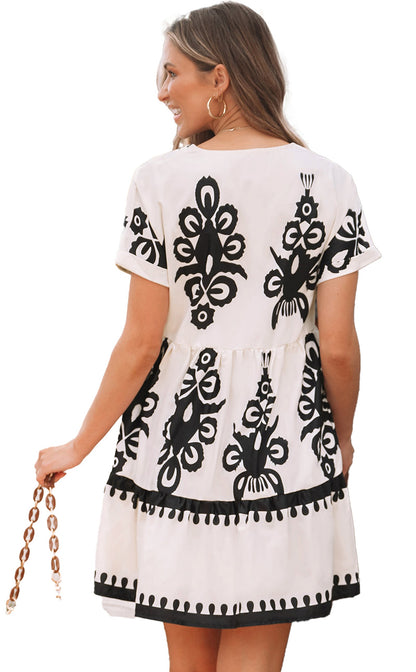 Back view of a black vintage print v neck dress by LuckeLadybug featuring a tiered design and short sleeves
