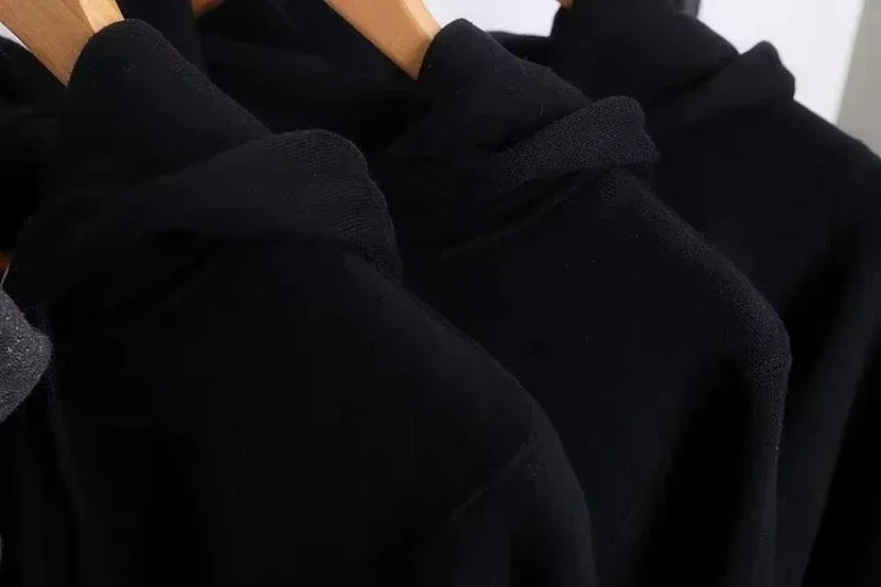 Close-up of Black Womens Hoodie Sweatshirt hanging on a wooden rack showcasing its soft fabric