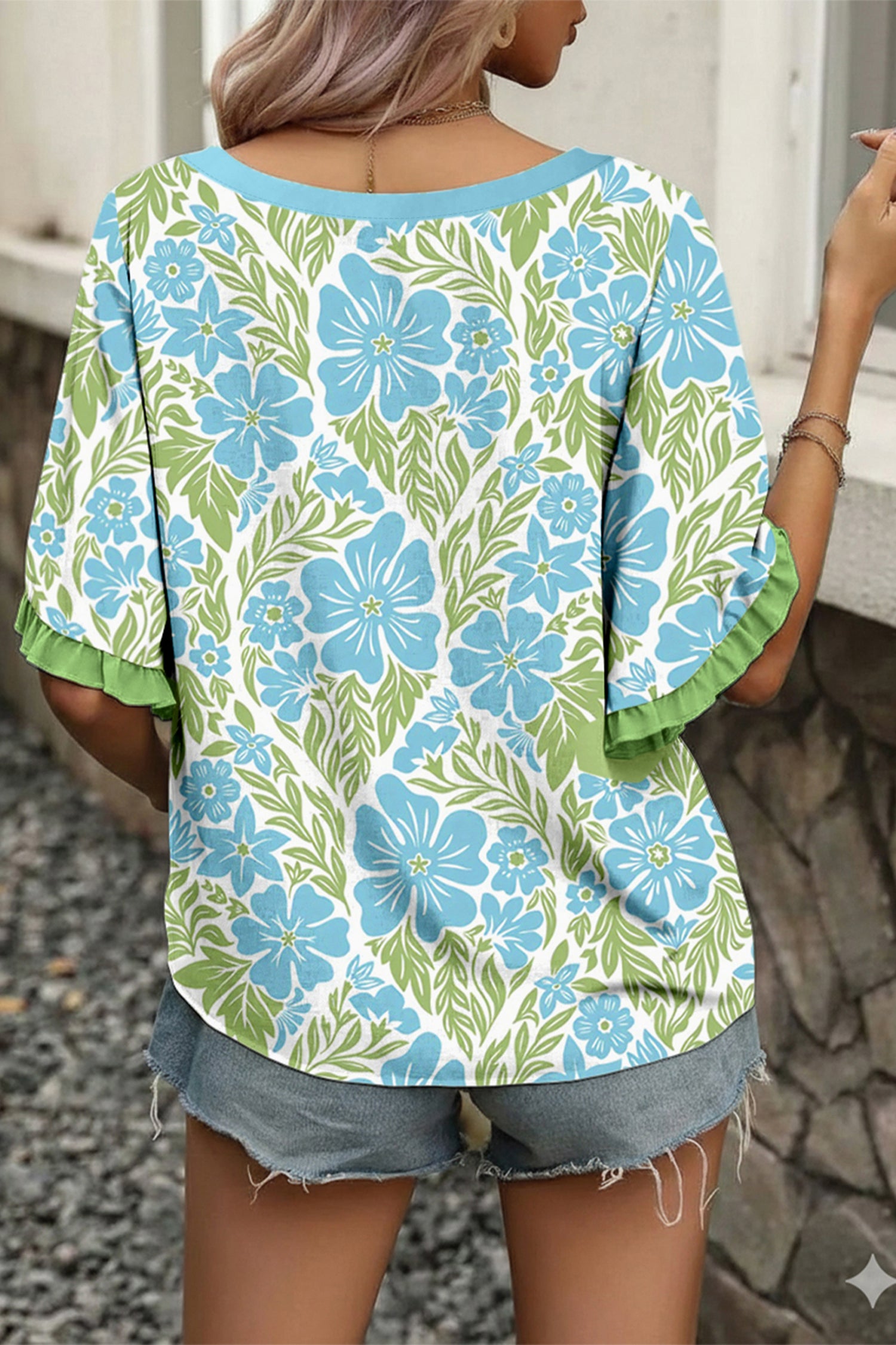 LuckeLadybug LLC Floral Blouse featuring a vibrant blue floral pattern on a green background