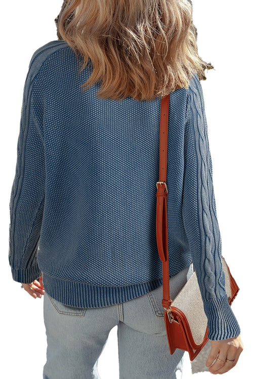 Back view of a blue cable knit sweater for women with textured fabric and relaxed fit