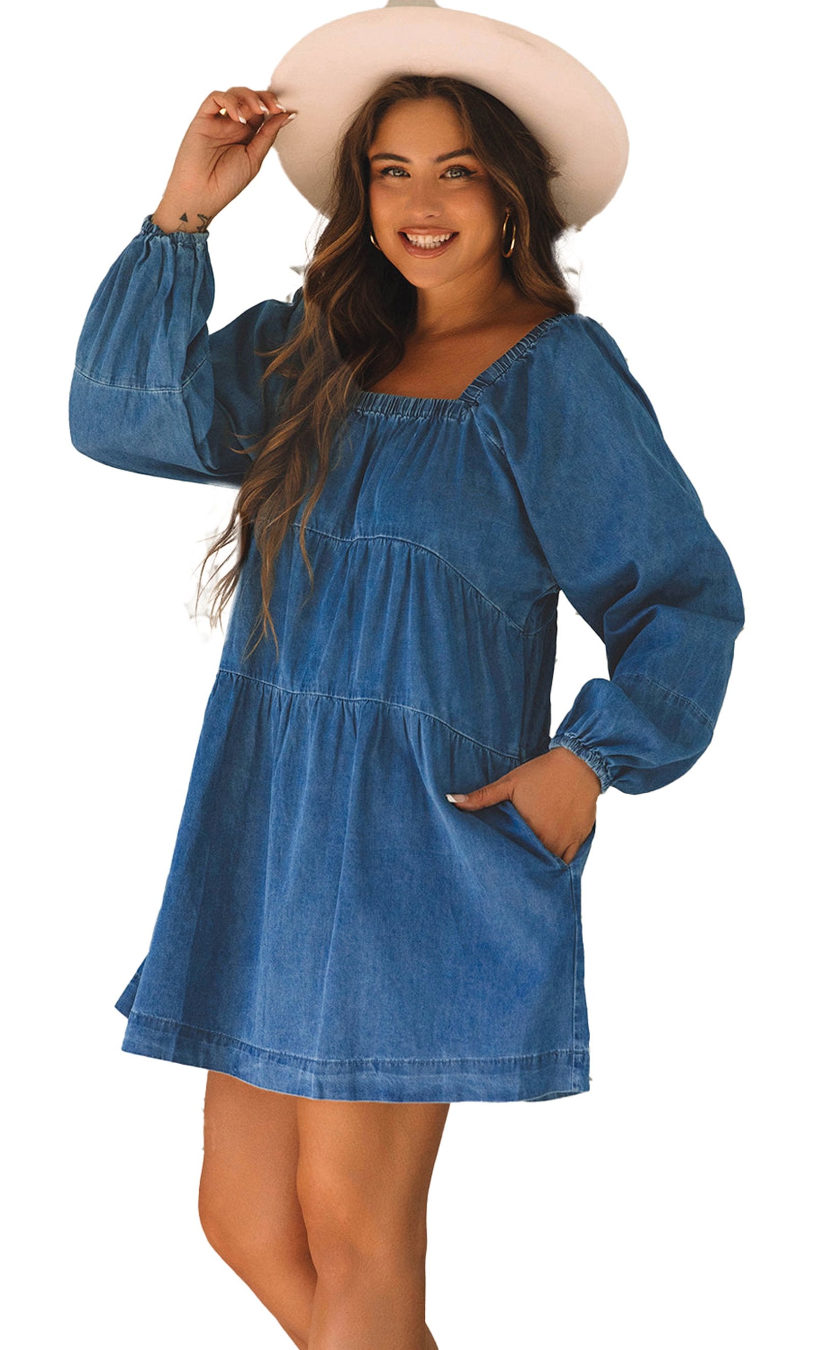Model wearing dusk blue denim mini dress with square neckline long balloon sleeves tiered skirt and side pockets