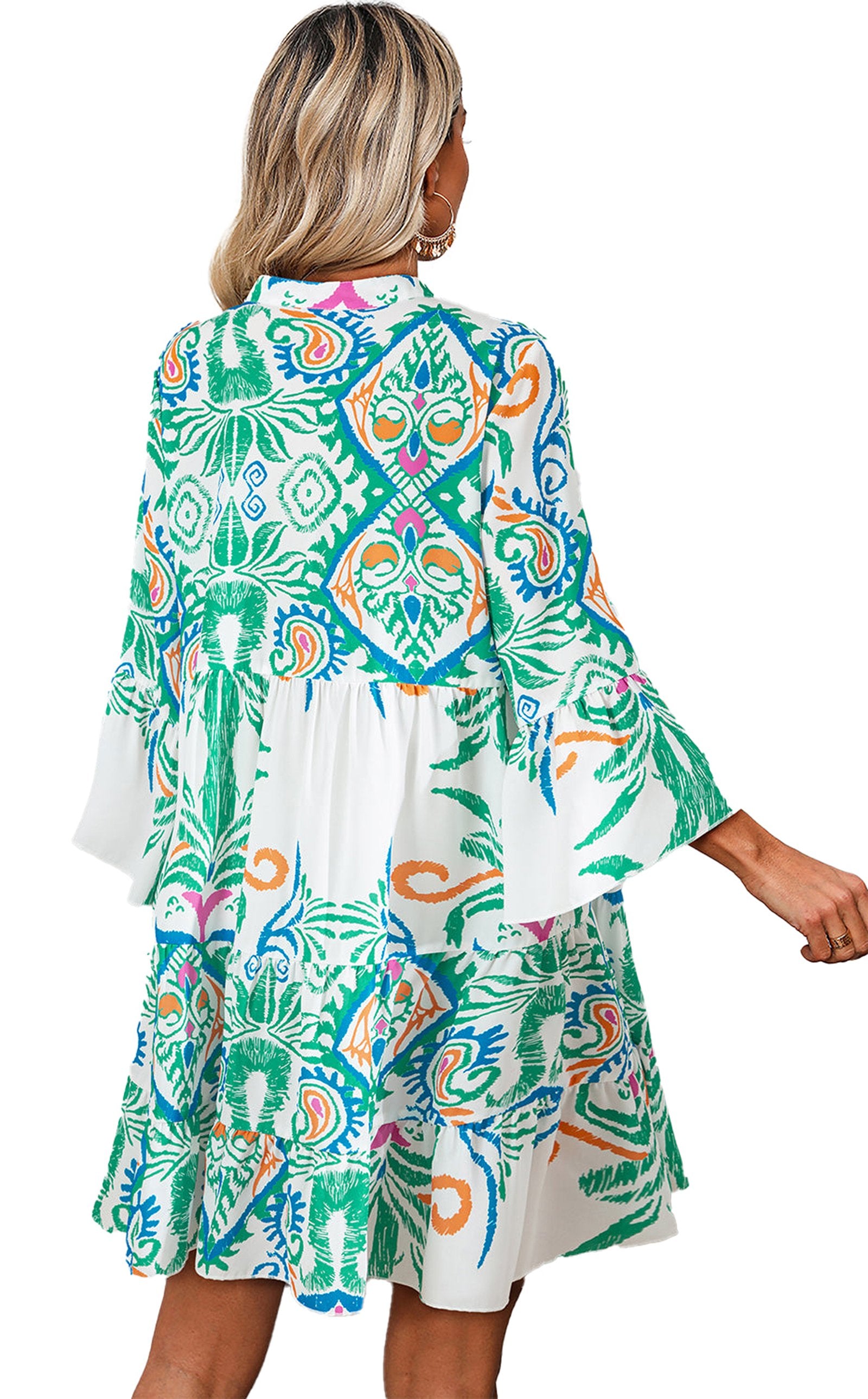 Back view of model wearing LuckeLadybug white tribal print mini dress with flared bell sleeves and vibrant green blue pattern