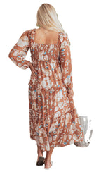 Rear view of woman in brown floral maxi dress with smocked square back long sleeves and tiered skirt