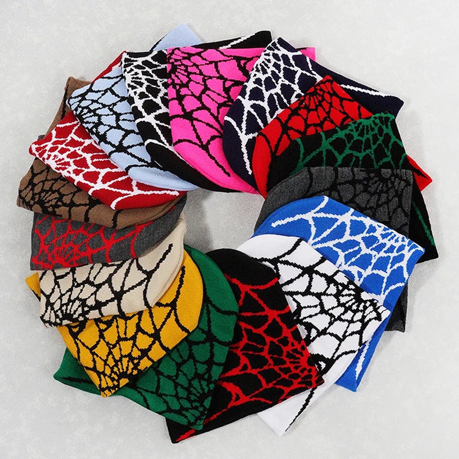 A collection of colorful beanies featuring a cartoon spider embroidered beanie design with spider web patterns