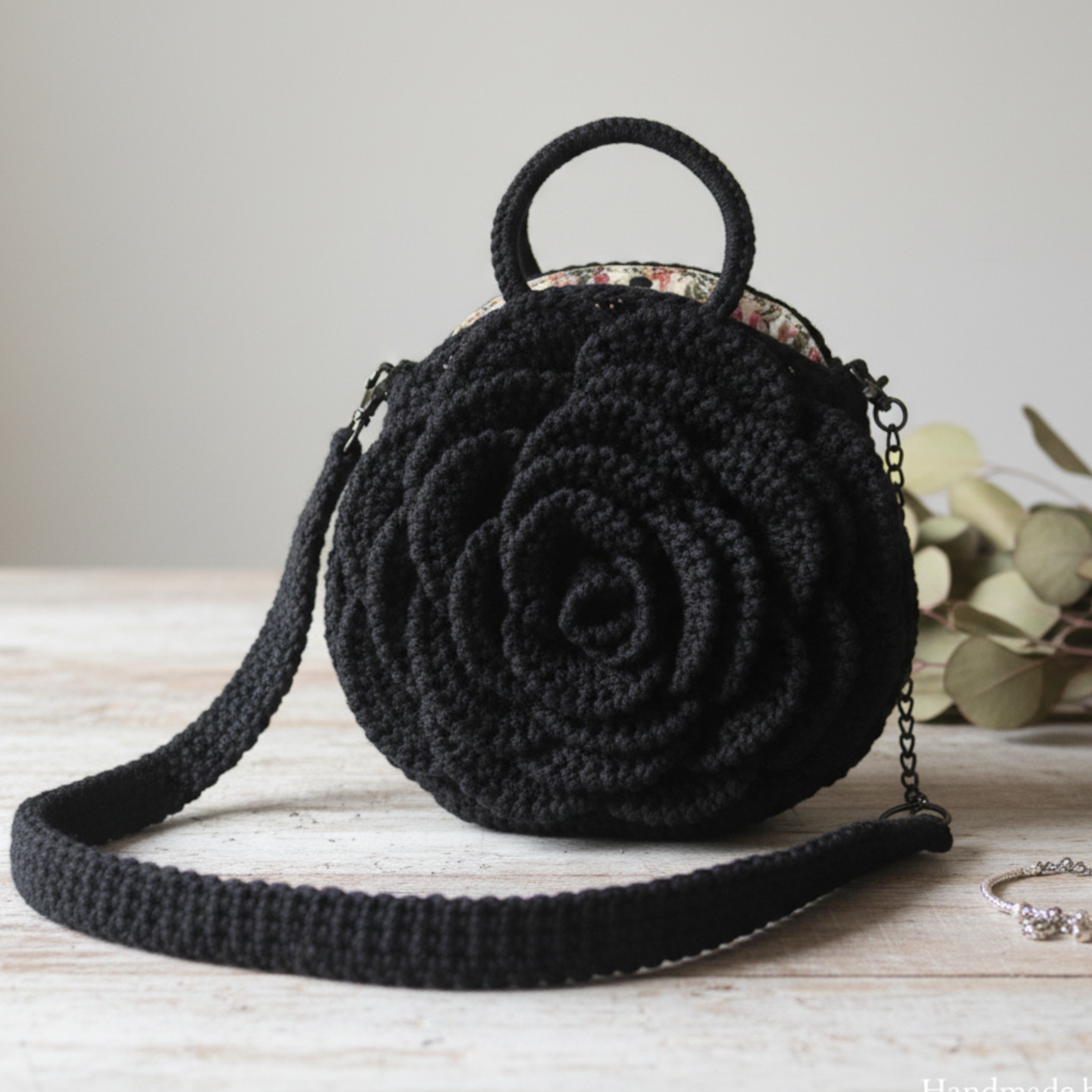 Handmade black crochet crossbody bag resembling a rose with a trendy design, perfect for stylish outings
