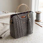 Gray crochet tote with gold handles and tassel detail, perfect as a coach purse shoulder bag