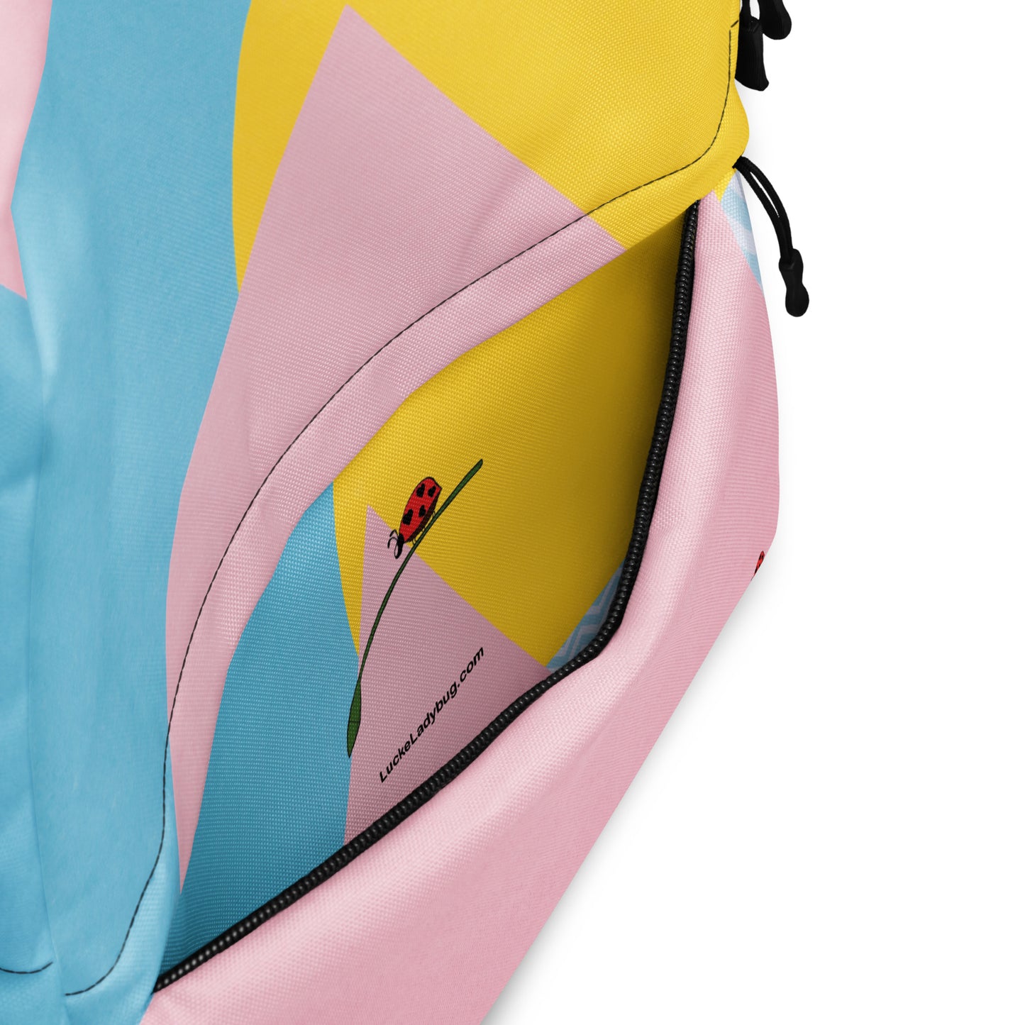LuckeLadybug colorful trendy backpack close-up of pink, yellow, and blue fabric with zipper and ladybug logo