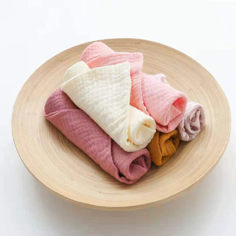 Soft and absorbent cotton washcloths in pastel colors arranged in a bowl