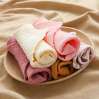 Set of vibrant cotton washcloths in various colors stacked in a bowl for everyday use