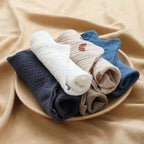 Set of soft cotton washcloths in various colors folded neatly on a plate