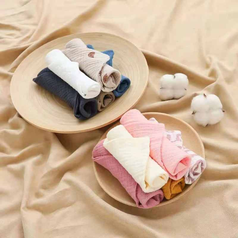 Soft cotton washcloths in a variety of colors neatly arranged in wooden bowls