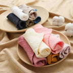 Soft and colorful cotton washcloths neatly rolled in a wooden bowl, perfect for daily use