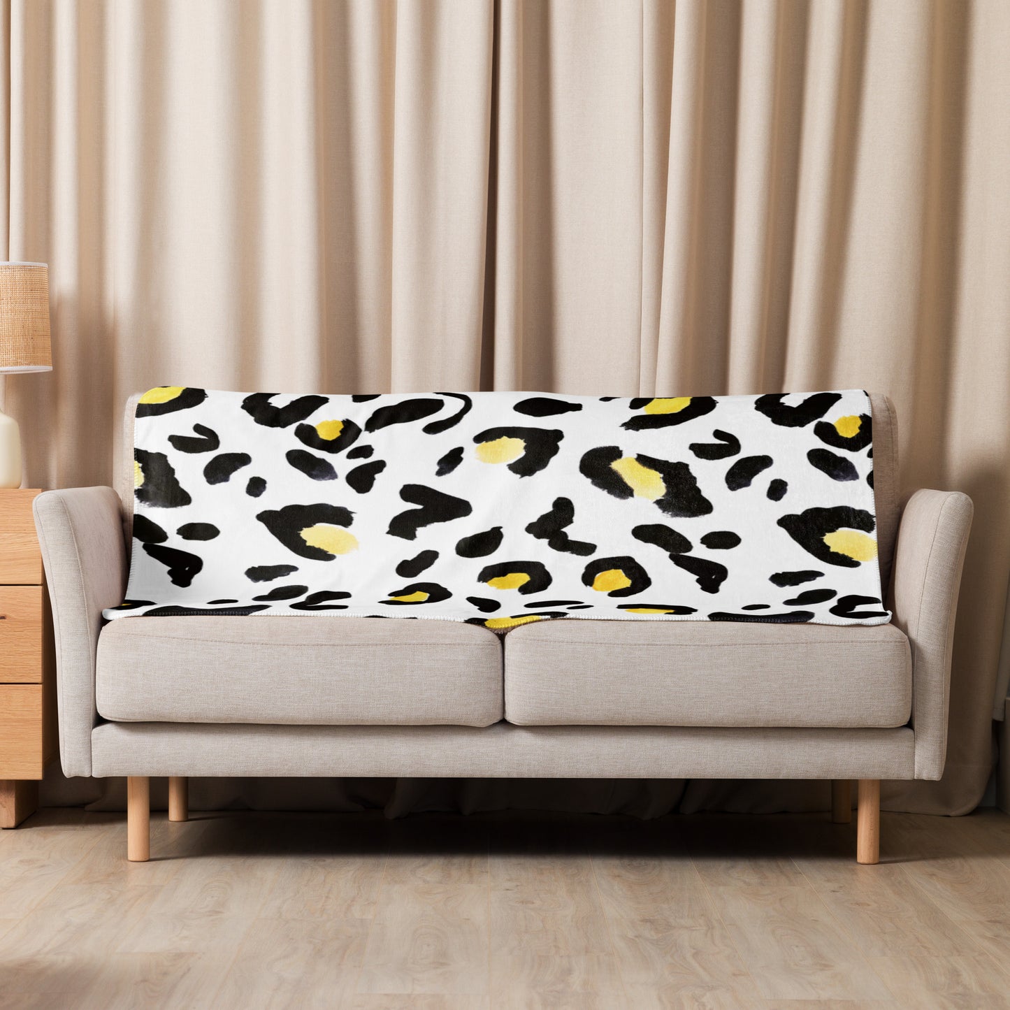 LuckeLadybug sherpa blanket with cozy animal print bedding draped over beige sofa in living room