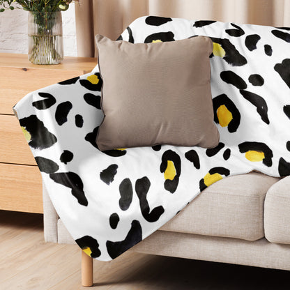 LuckeLadybug sherpa blanket with cozy animal print bedding in black and yellow spots on white sofa