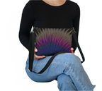 LuckeLadybug vegan leather punk crossbody bag with colorful abstract design worn by seated person