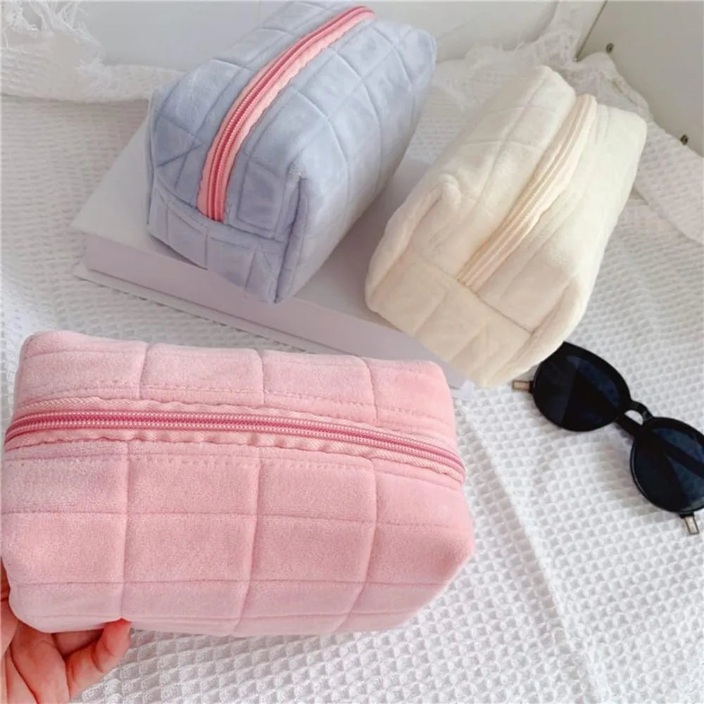 Cute plush makeup bag in pink, gray, and cream with a zip closure and soft texture