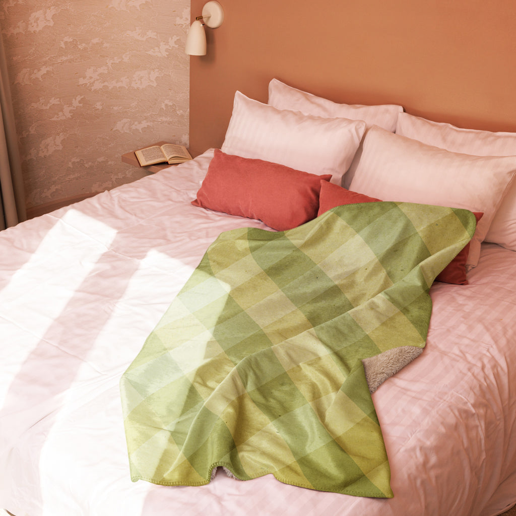 LuckeLadybug Sherpa blanket with diamond pattern bedding design in green draped on a bed with soft pillows