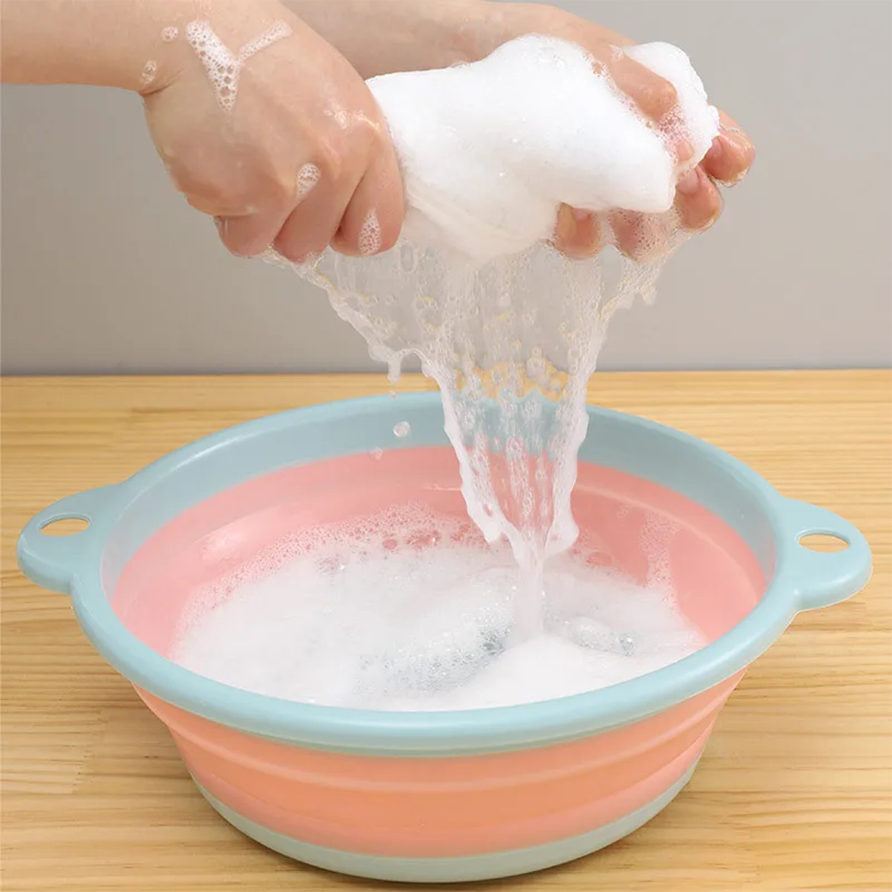 Cleaning Kit for diaper cloth with hands washing in soapy water in a colorful basin