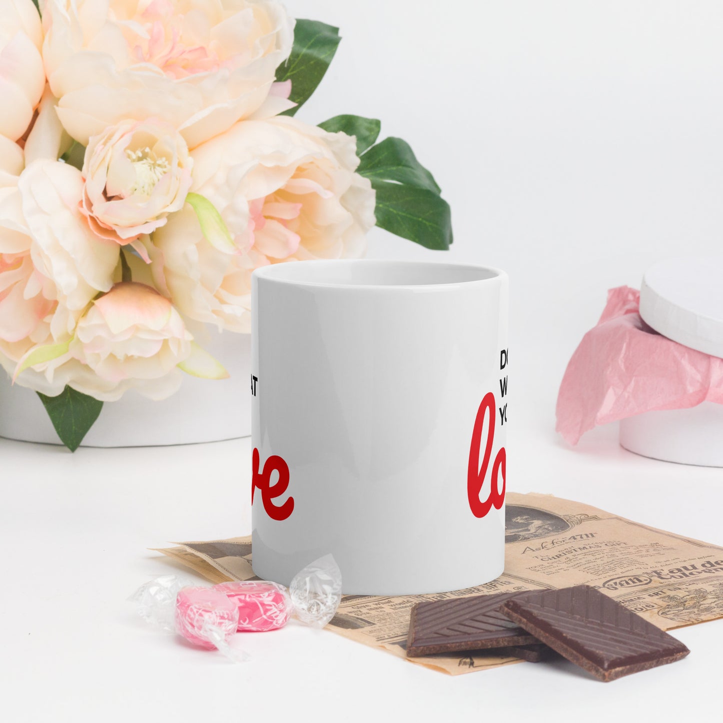 LuckeLadybug do what you love coffee mug white ceramic with red text on table with flower and candy