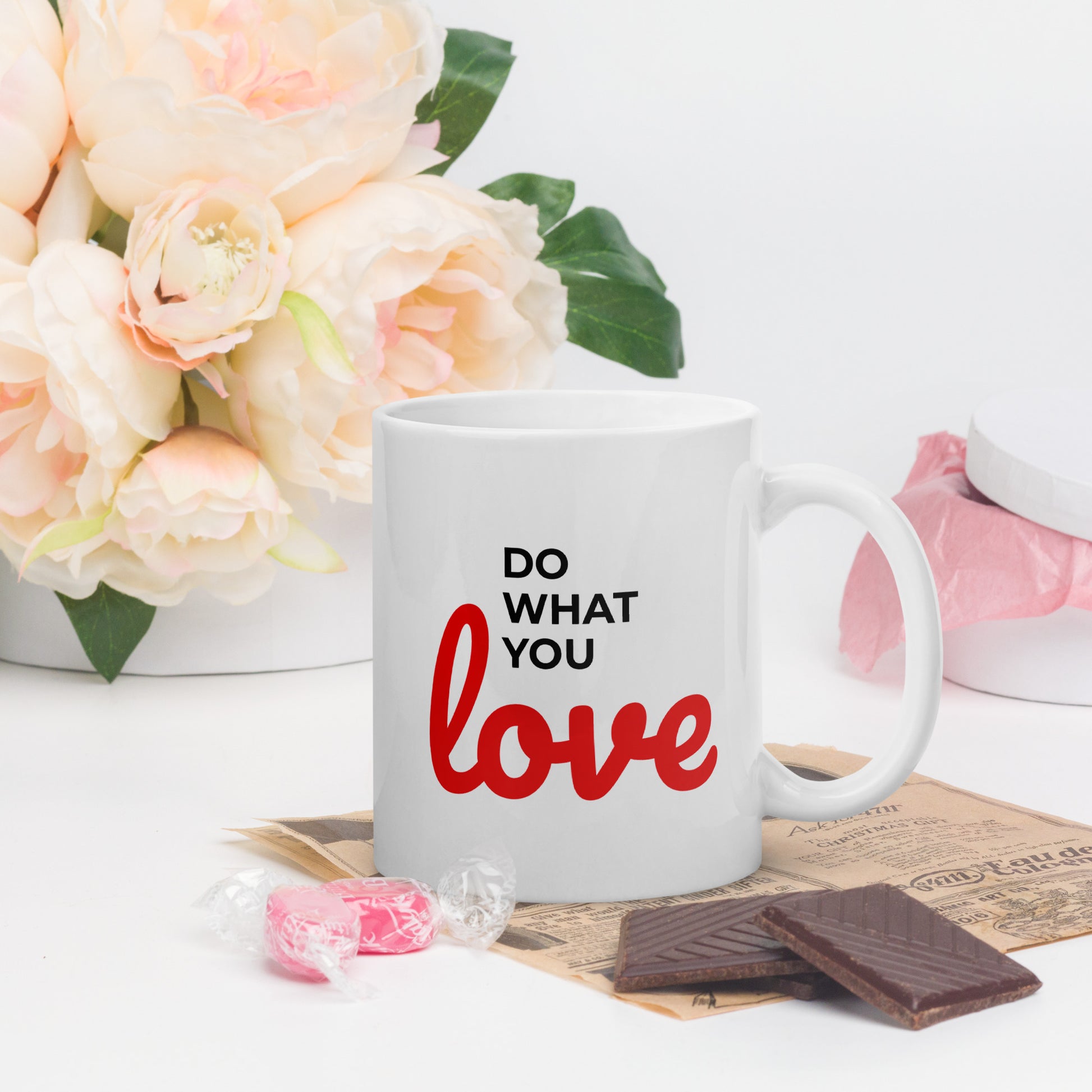 LuckeLadybug do what you love coffee mug with red and black text next to candy and chocolate