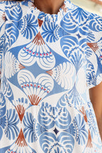 Lightweight fit and flare dress for vacation featuring a tropical leaf print in blue and white