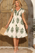 Fit and flare dress for vacation featuring green floral print and a tiered skirt, perfect for warm weather