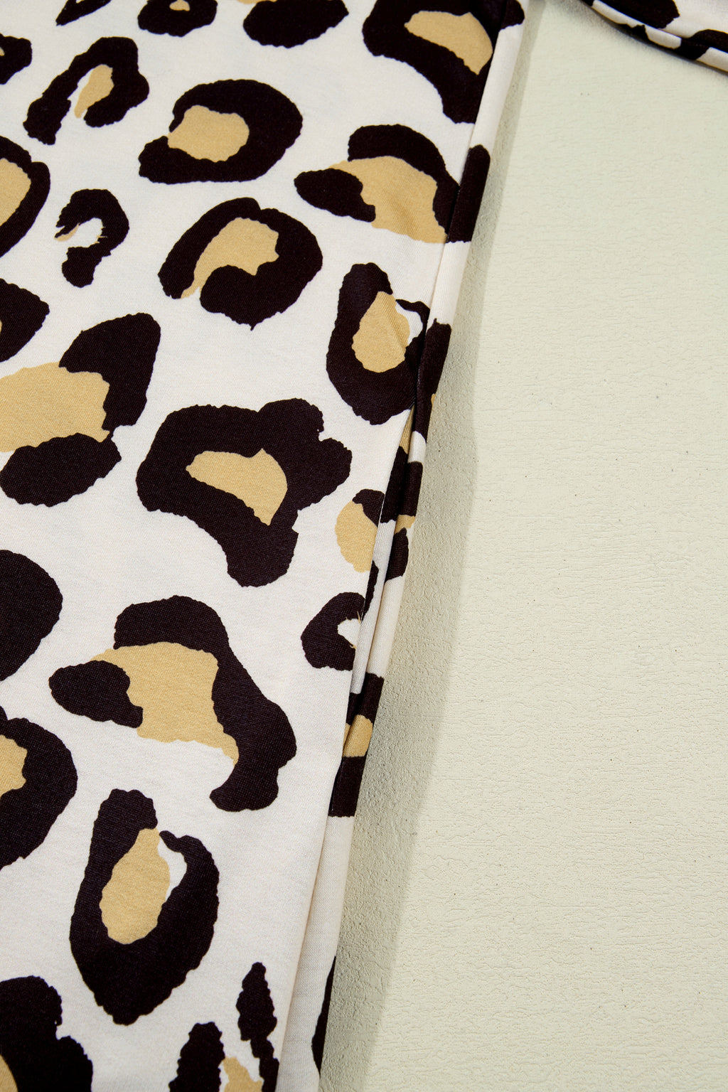 Close-up of a dress with leopard print featuring bold black and tan patterns on a light background