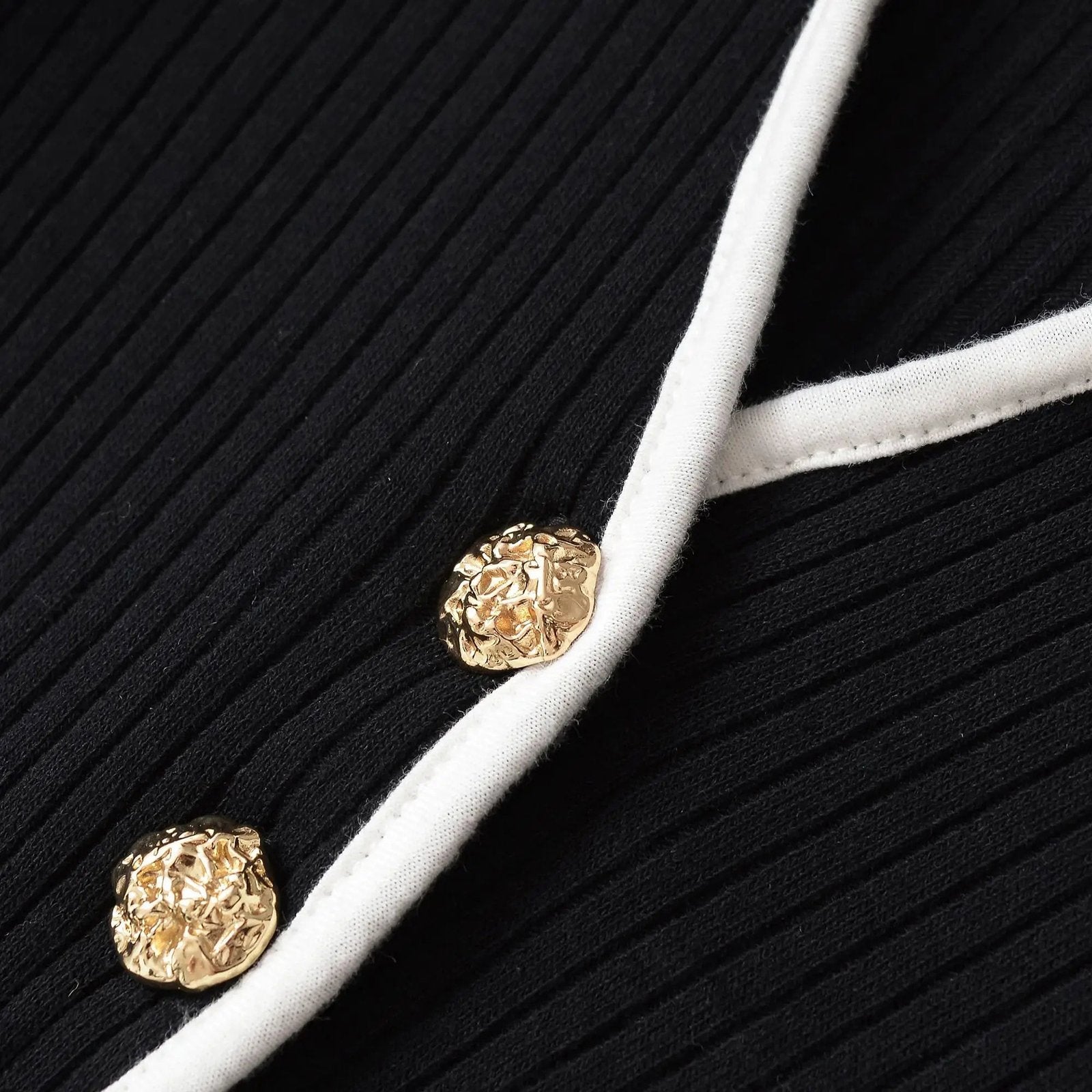 Close-up of elegant mini dress for women featuring gold buttons and ribbed fabric detail